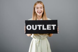 Tjej som håller upp outlet-skylt