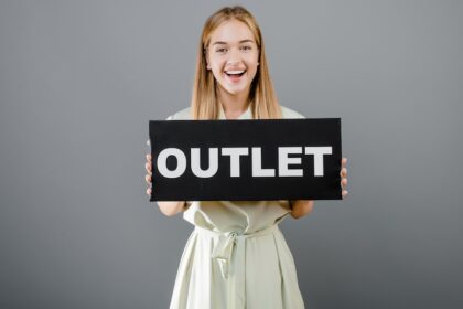 Tjej som håller upp outlet-skylt